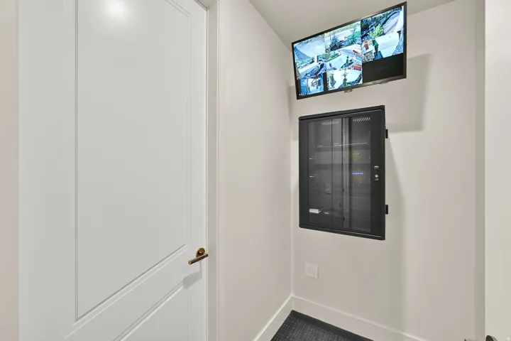 Integrated security monitoring system featuring a wall-mounted display and network cabinet
