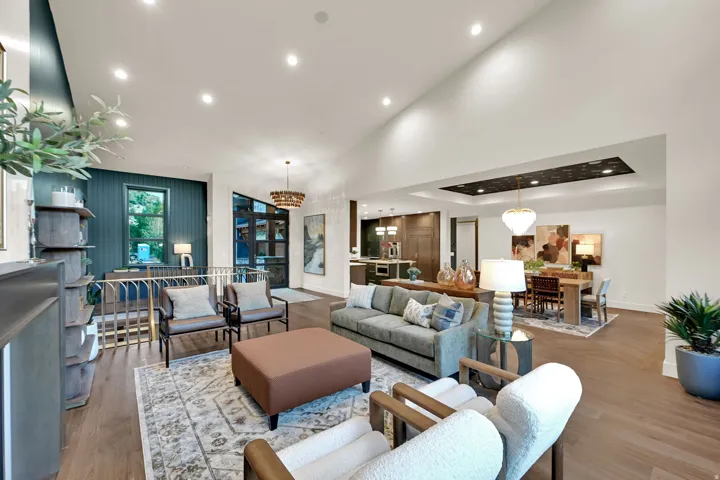 Expansive open-concept living area featuring high vaulted ceilings, recessed lighting, and wood-finish flooring