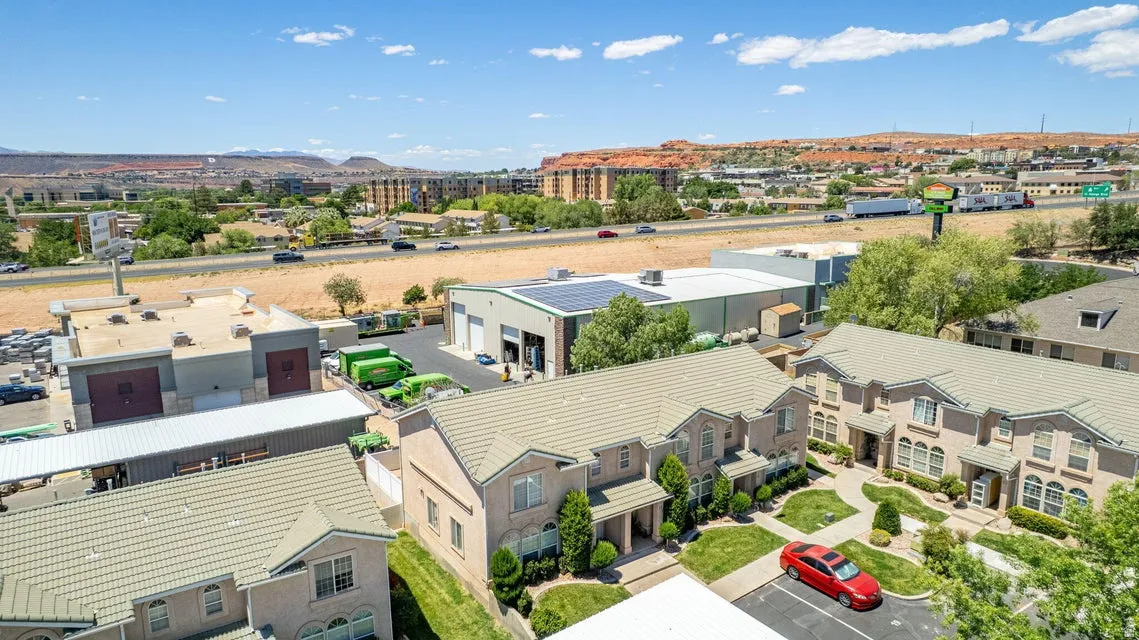 Townhome-style residences featuring light-colored stucco exteriors and complementary tiled roofs