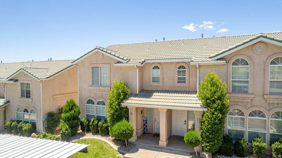 Multi-level townhouse exterior featuring stucco siding and a tiled roof