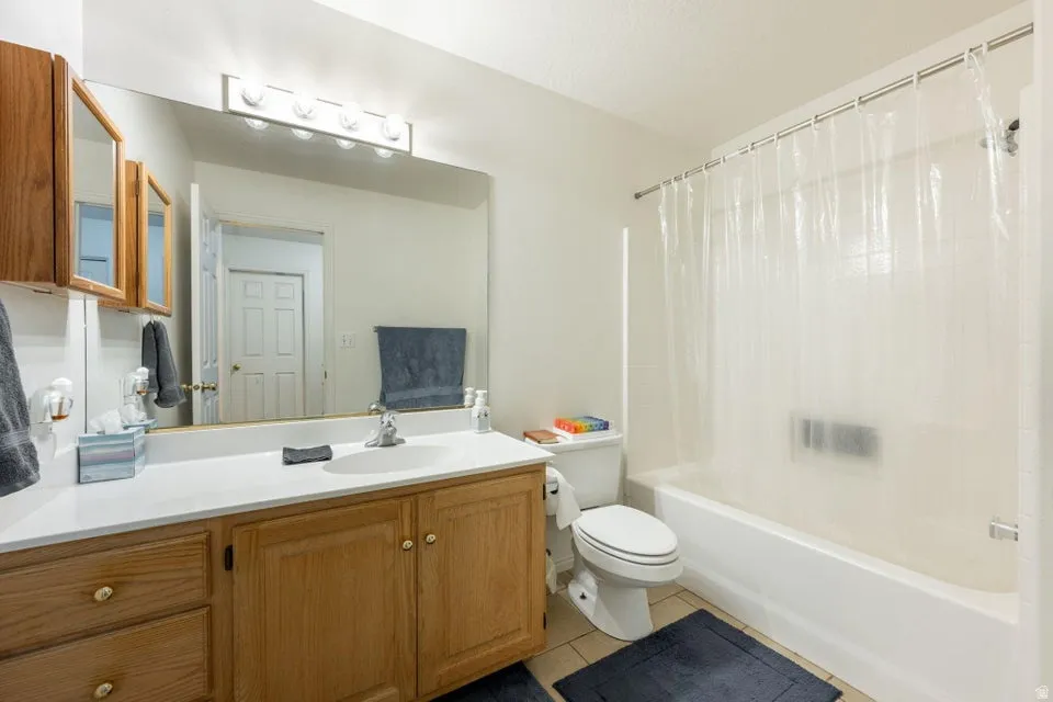 Full bathroom featuring a single vanity with wood cabinetry, a white countertop, and an integrated sink