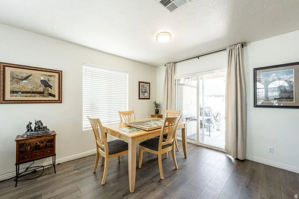 Spacious room featuring wood-finish flooring, white walls, and a recessed ceiling light