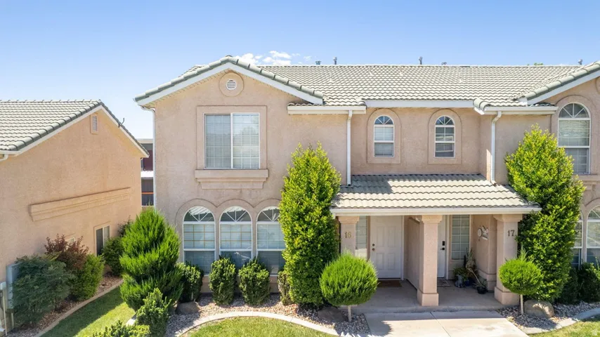 Stucco exterior featuring a tiled roof and arched windows