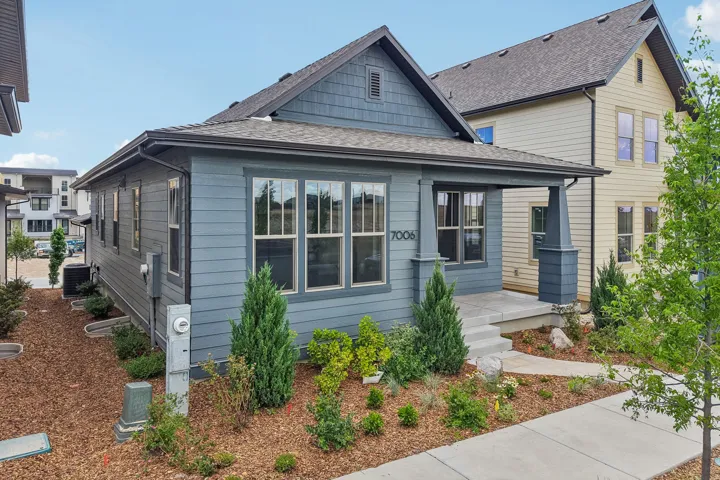 Single-story residence featuring a covered front porch with substantial columns, horizontal siding, and architectural shingles