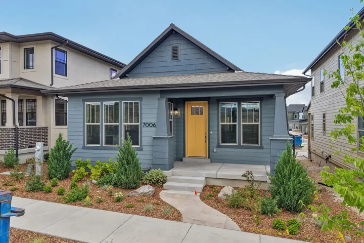 Contemporary single-story residence featuring blue siding and a vibrant yellow front door