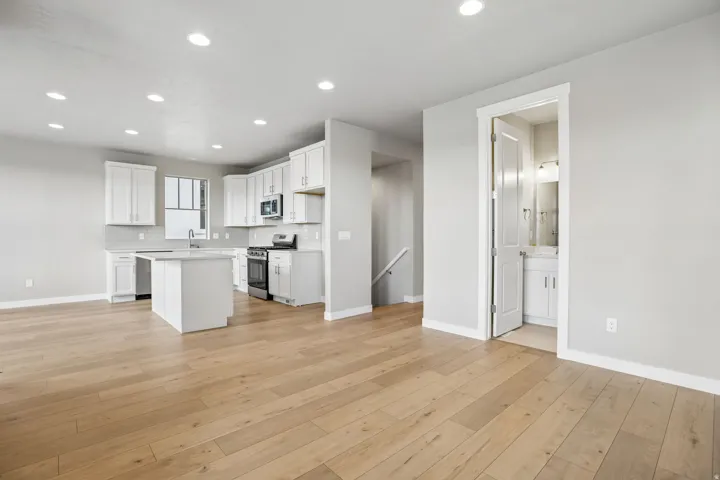 Open-concept living space with wood-finish flooring, recessed lighting, and a modern kitchen
