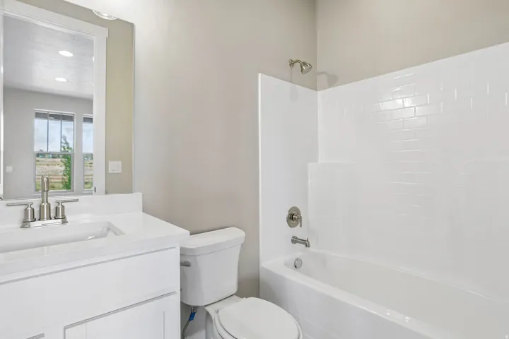 Contemporary bathroom featuring a single vanity with a white countertop and undermount sink, brushed nickel faucet, and a large mirror