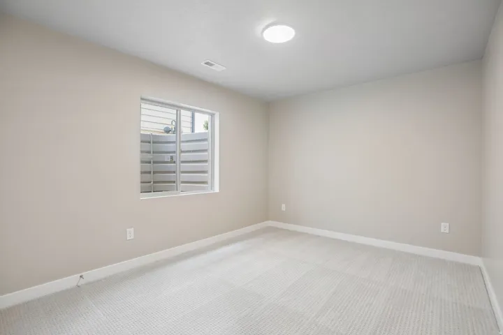 Neutral-toned walls complement the light patterned carpeting
