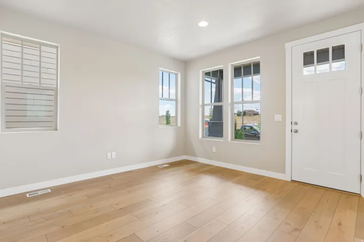 Entryway featuring a paneled door with upper lites, wood-finish flooring, recessed lighting, and multiple windows