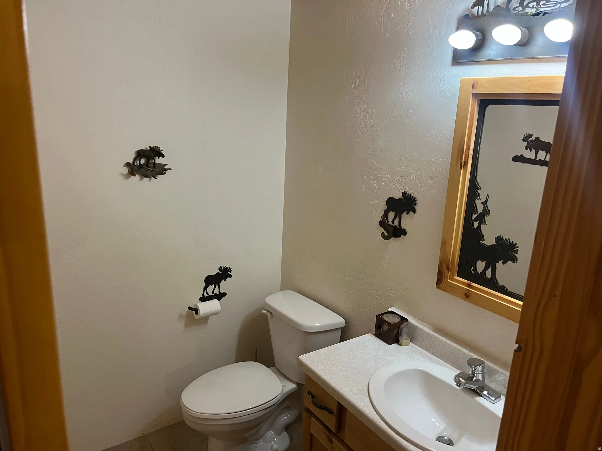Bathroom featuring a vanity with a white oval sink, chrome faucet, and light-toned countertop