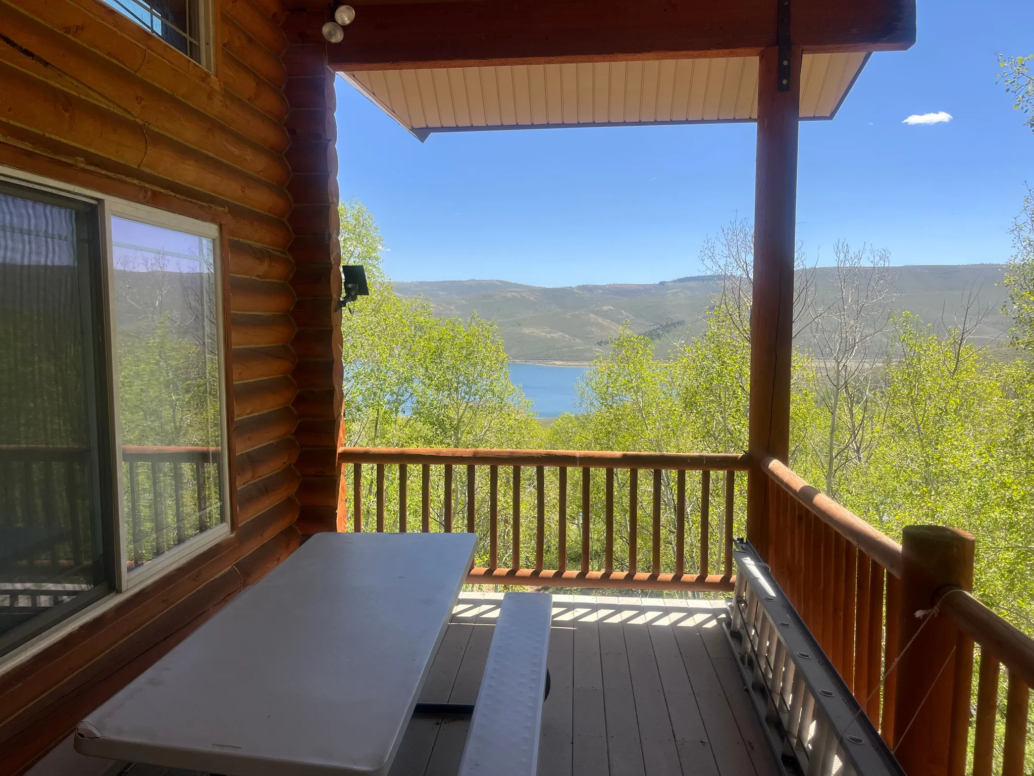 Covered deck featuring wood-finish siding, wood railings, and composite decking