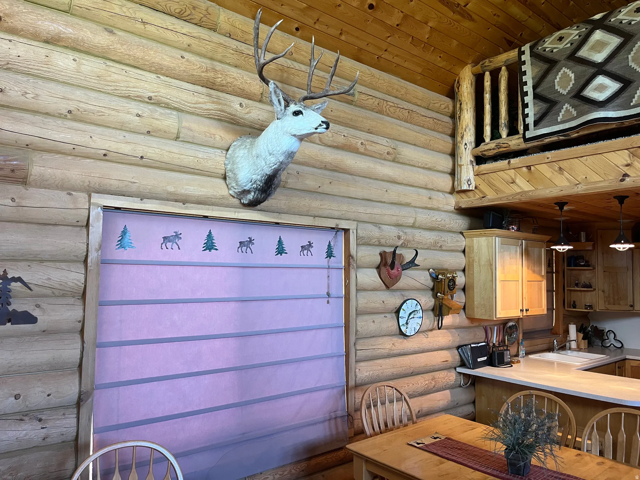 Log cabin interior featuring exposed wood walls and a high vaulted ceiling