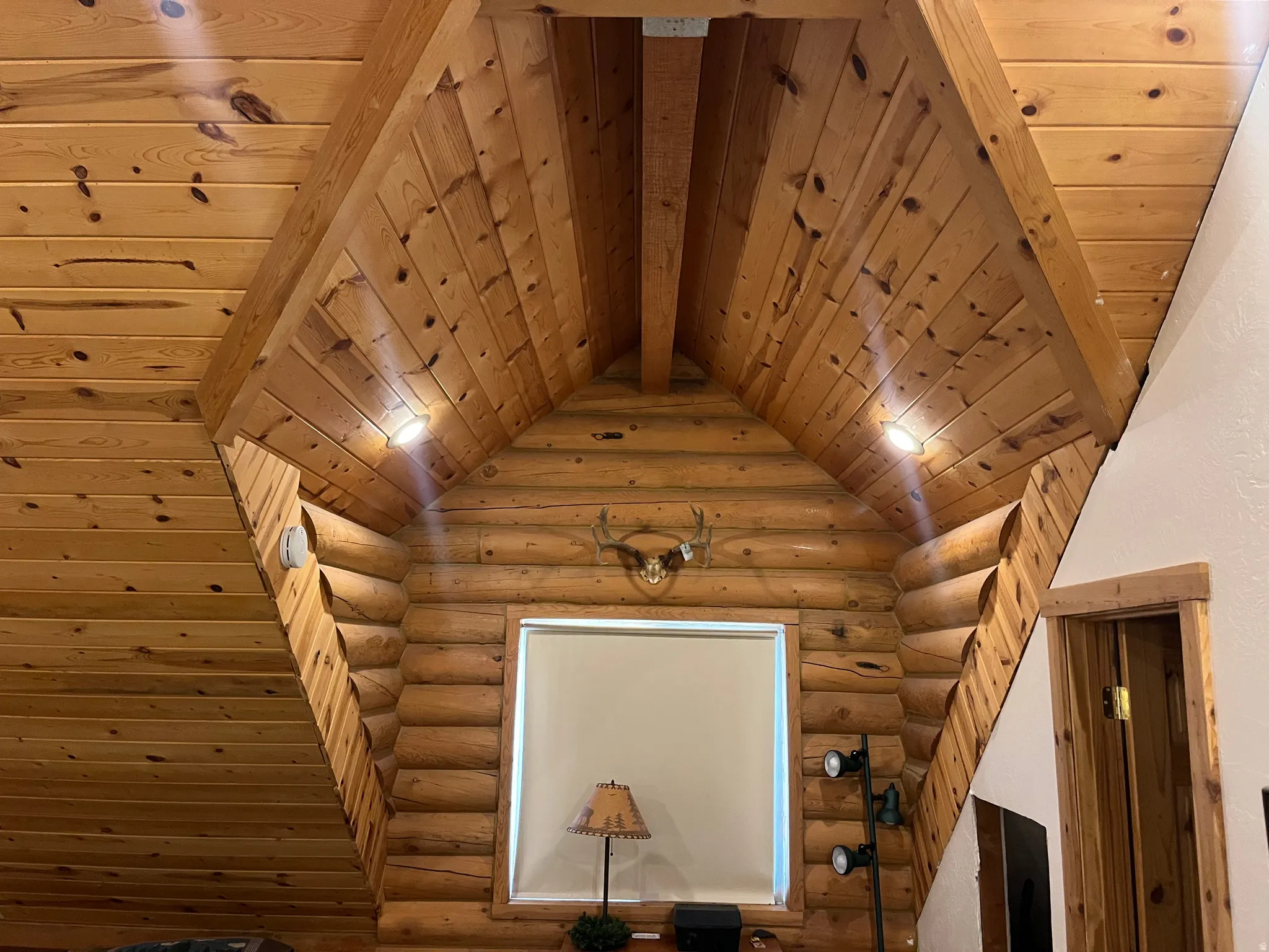 Vaulted wood-paneled ceilings with exposed beams and recessed lighting