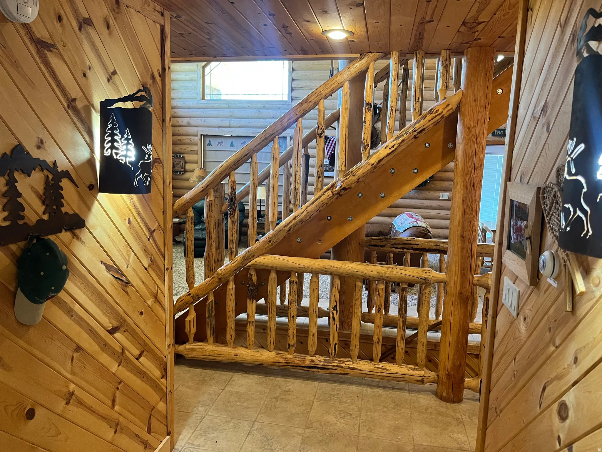 Rustic wood staircase featuring log newel posts and spindles