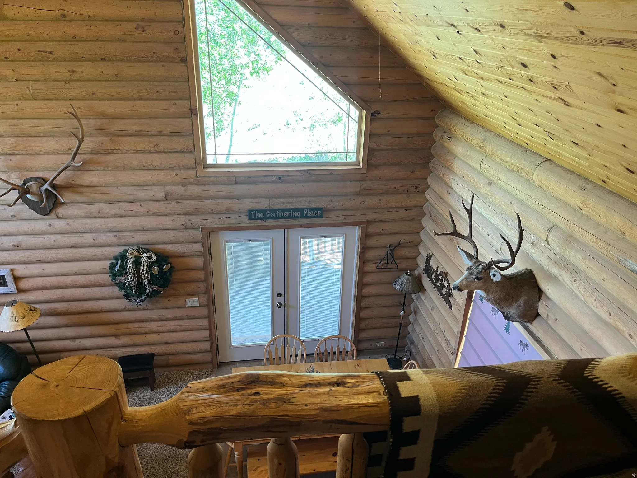 Vaulted interior featuring log construction and exposed wood ceiling