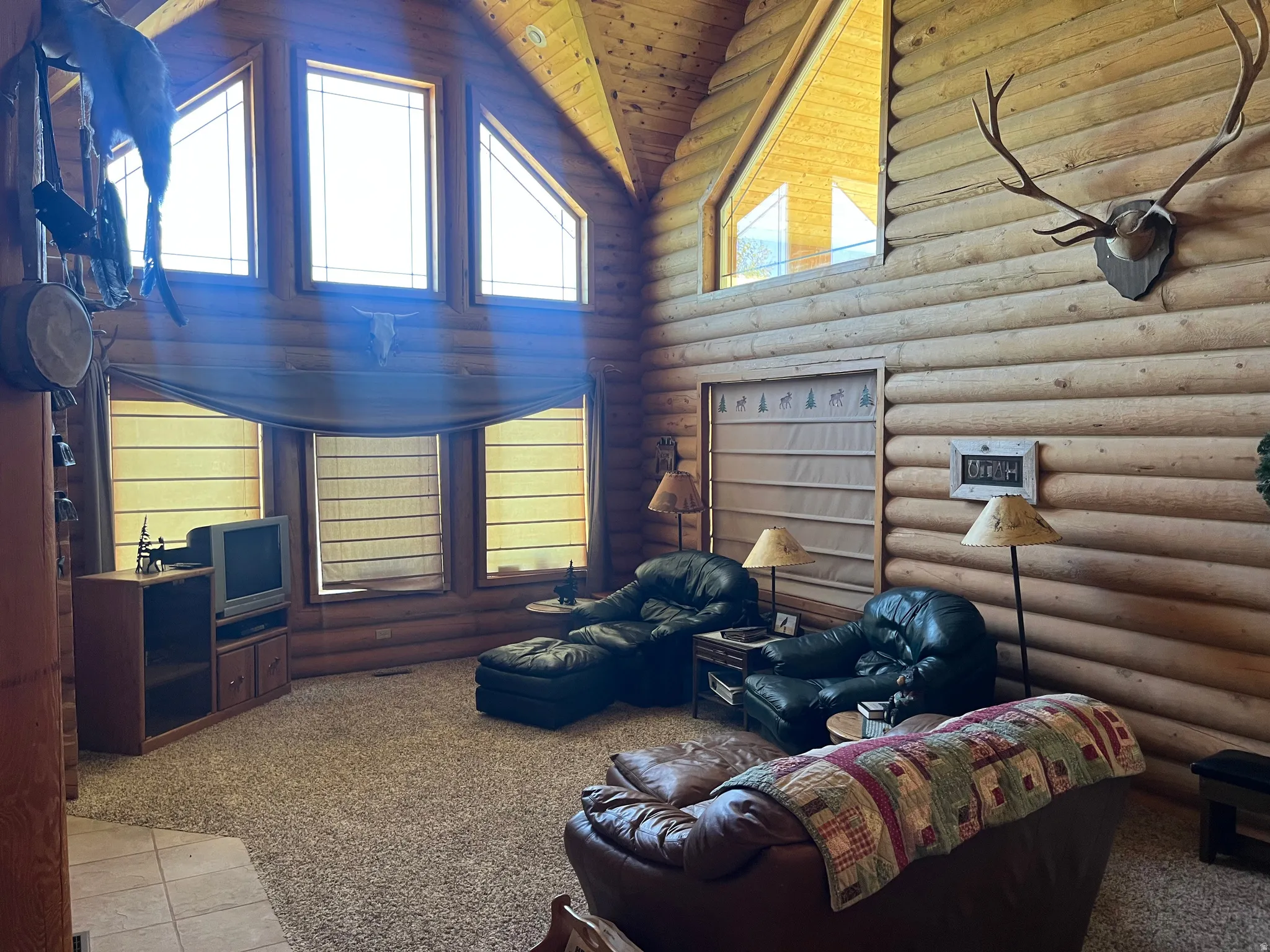 Expansive living space featuring full log walls and a vaulted log ceiling