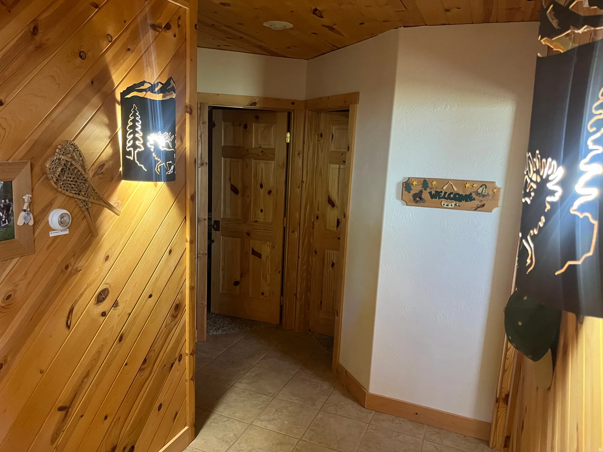 Wood-paneled walls and ceiling featuring two natural wood doors with panel detailing