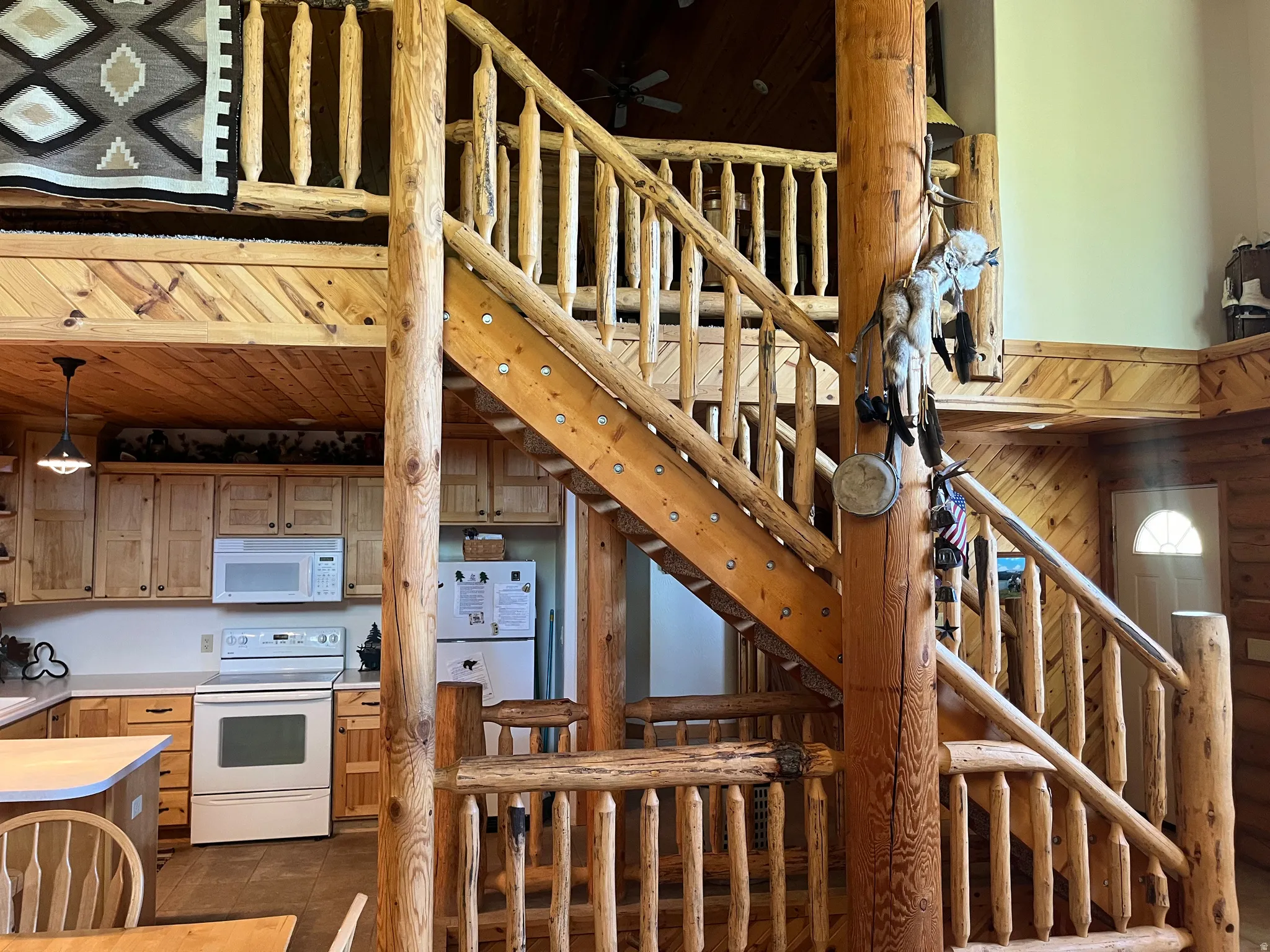 Rustic wood staircase featuring log newel posts and spindles