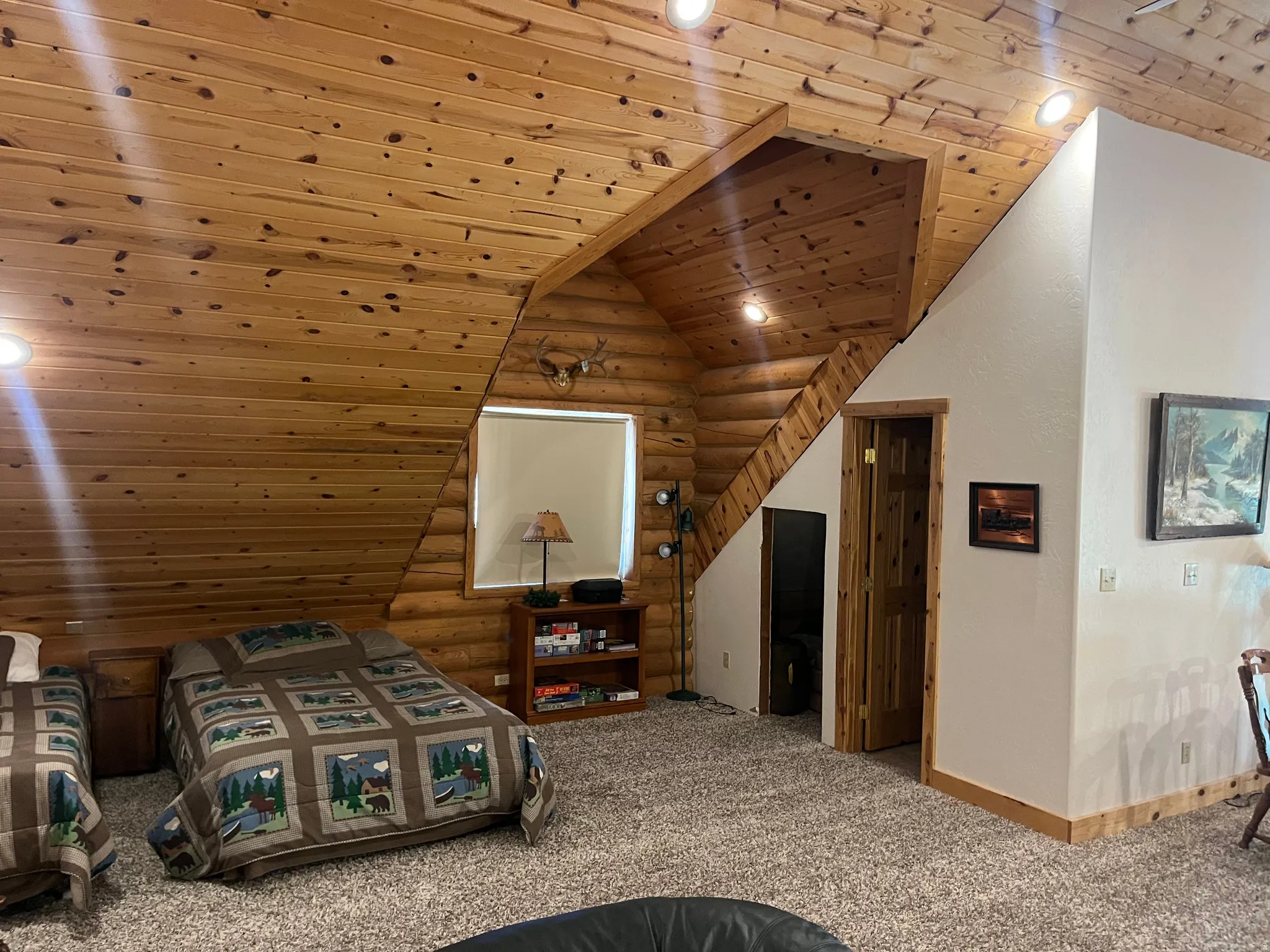 Warm interior space featuring extensive knotty pine wall and ceiling paneling, recessed lighting, and a textured carpeted floor