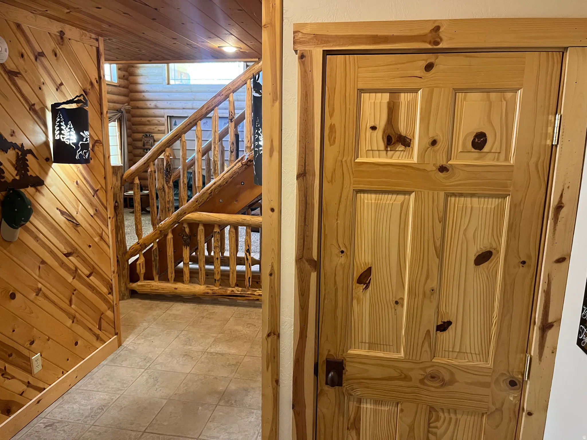 Natural wood paneled walls with a rustic wooden staircase
