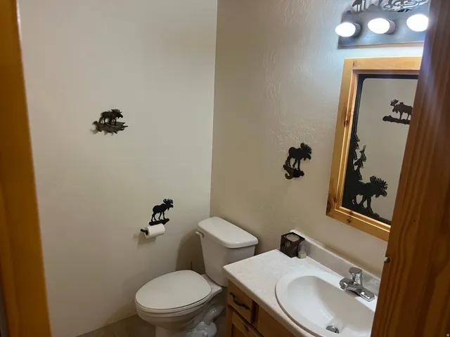 Bathroom featuring a vanity with a white oval sink, chrome faucet, and light-toned countertop