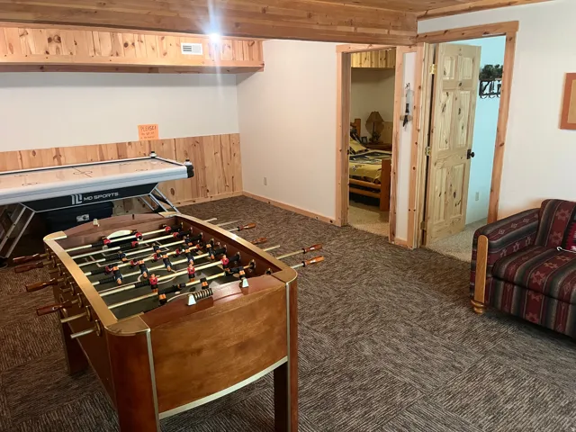 Interior space featuring wood paneling, wood-finish ceiling, and carpeted flooring