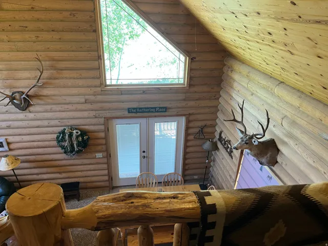 Vaulted interior featuring log construction and exposed wood ceiling