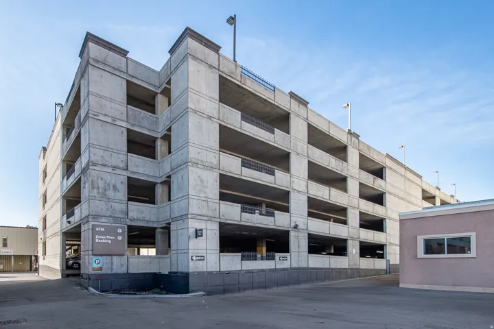 Multi-level concrete parking structure featuring multiple open-air levels and integrated lighting