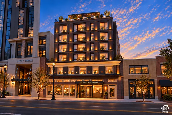 Multi-story facade featuring dark masonry, expansive grid-pattern windows, recessed lighting, and a rooftop terrace