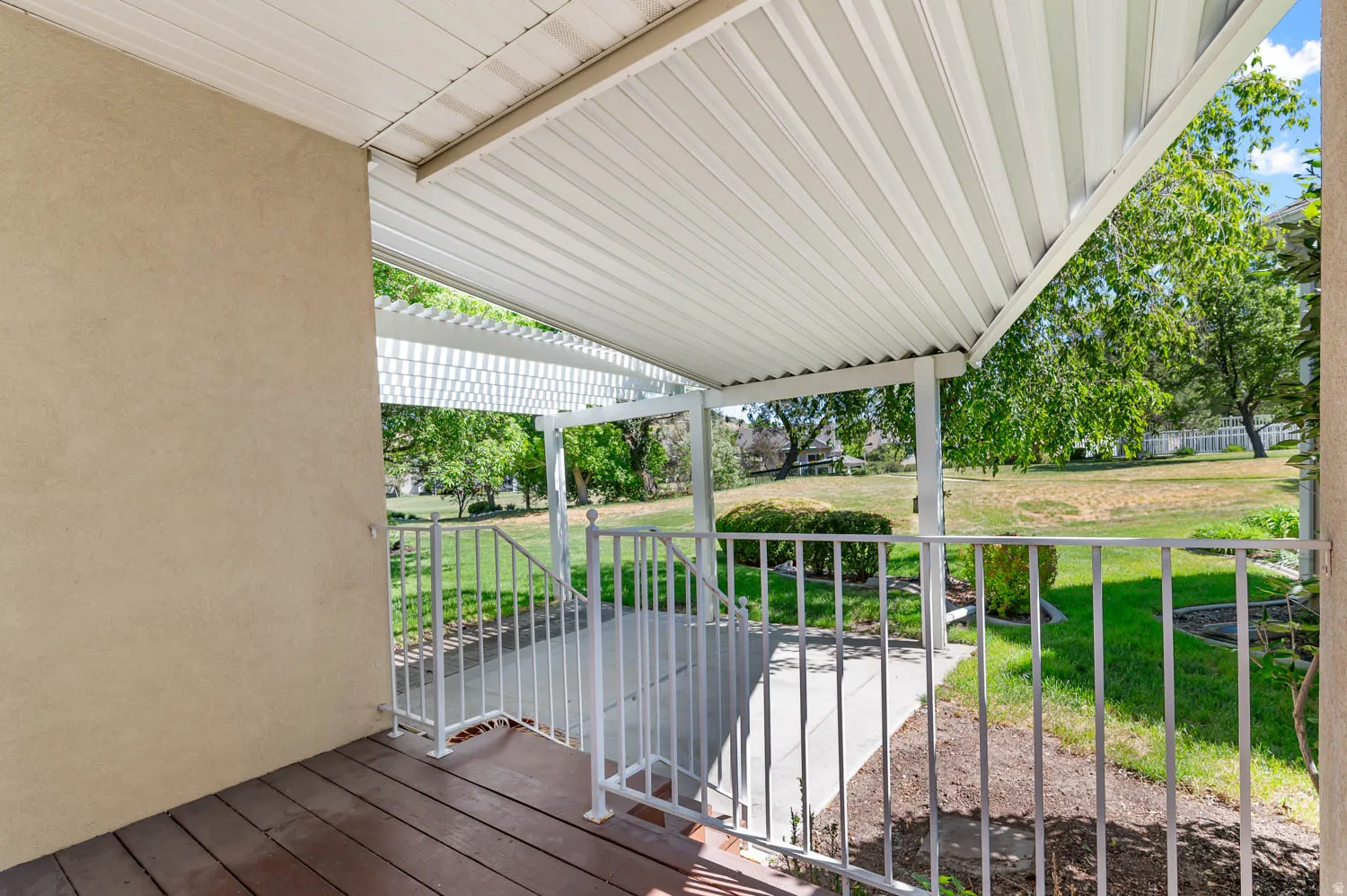 Covered outdoor patio area featuring a slatted ceiling and wood-finish flooring