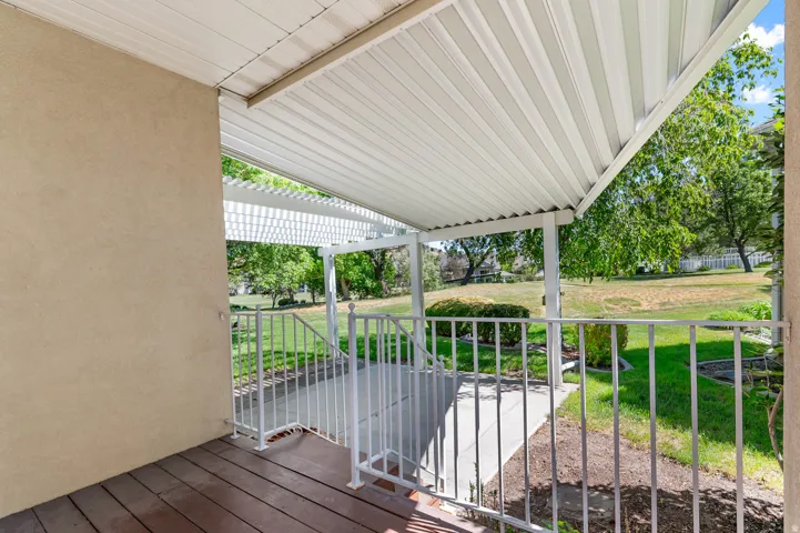 Covered outdoor patio area featuring a slatted ceiling and wood-finish flooring