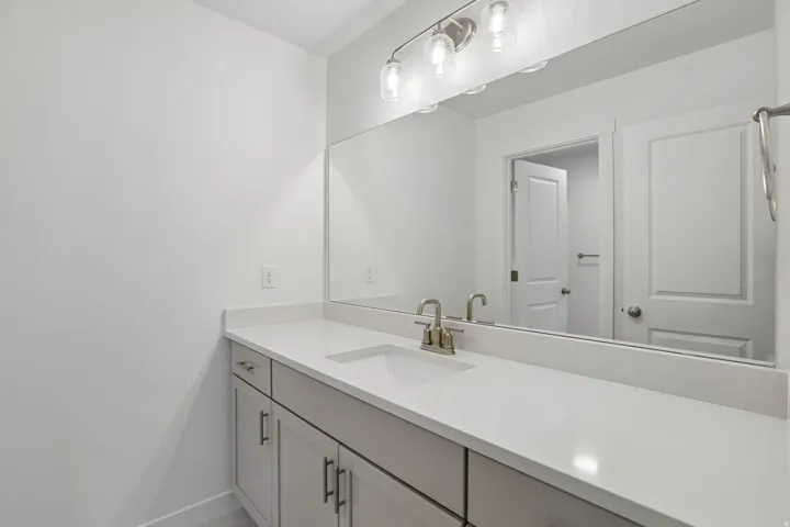 Bathroom vanity with a spacious countertop, integrated sink, and brushed nickel fixtures