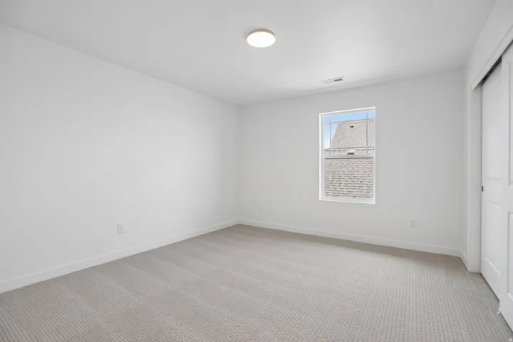 Room featuring light gray carpet flooring, white painted walls, and white baseboards