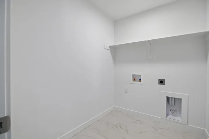 Utility space featuring white walls and a single white shelf