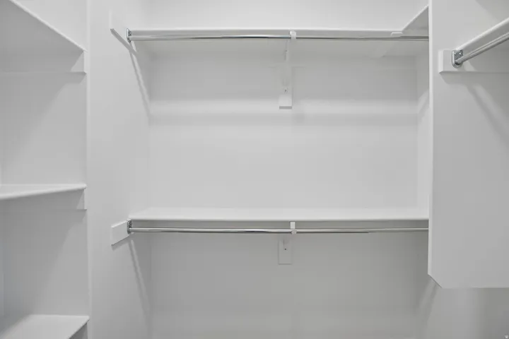 White closet system featuring multiple shelves and clothing rods