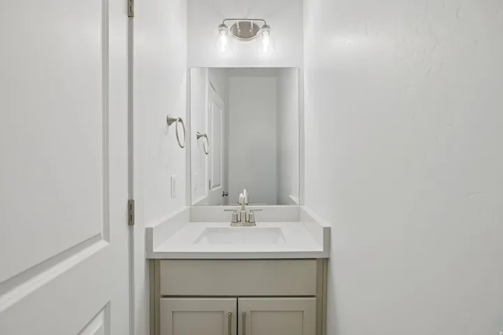 Vanity featuring a rectangular undermount sink, brushed nickel faucet, and light-toned countertop