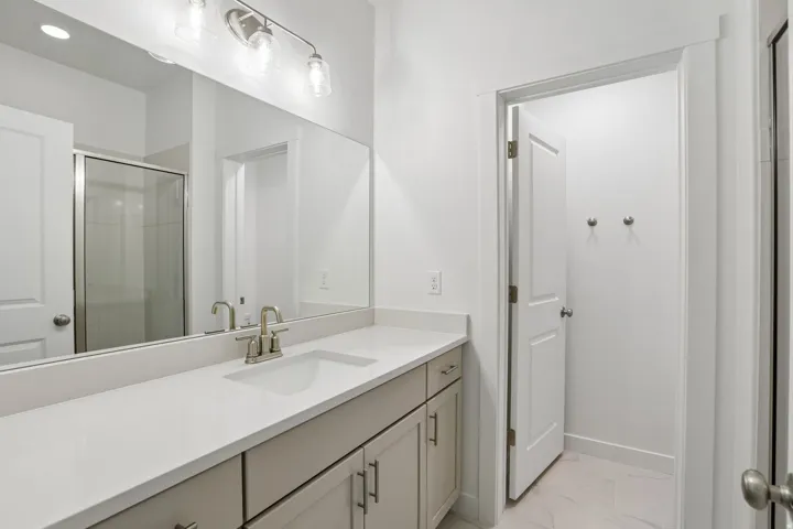 Bathroom featuring a single-sink vanity with a light countertop, brushed nickel faucet, and undermount sink