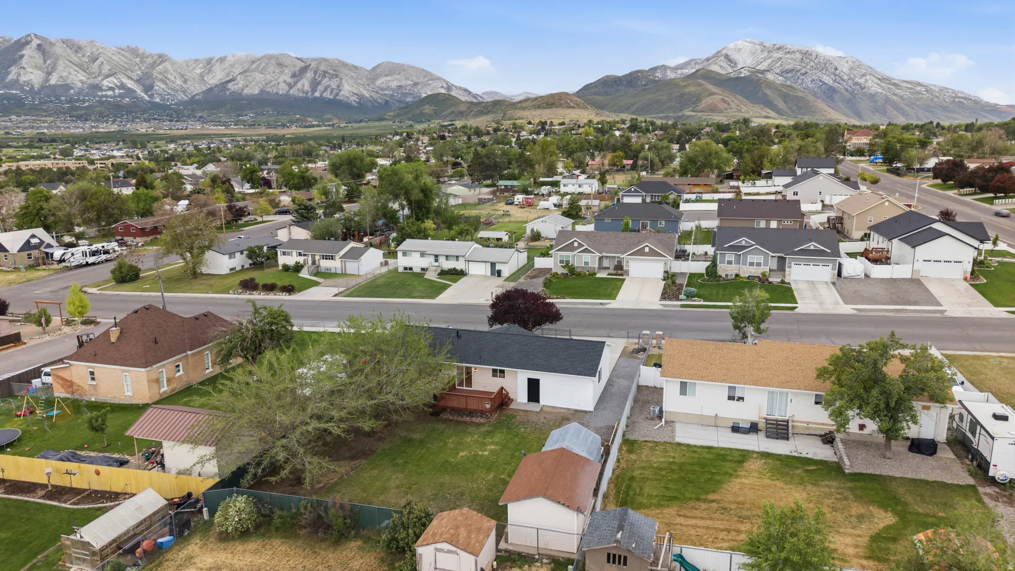 Residential neighborhood with mature landscaping and mountain backdrops