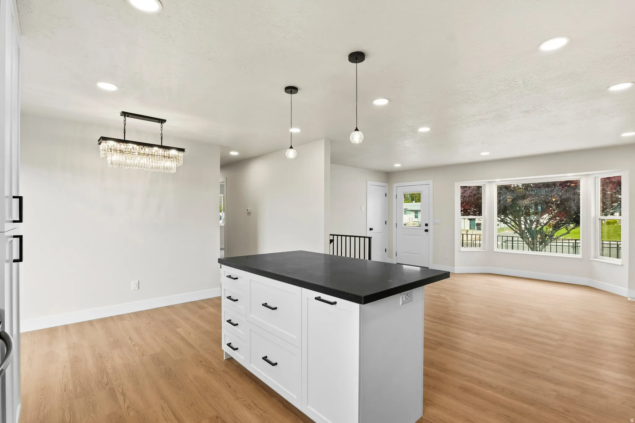 Central kitchen island with dark countertop and white cabinetry
