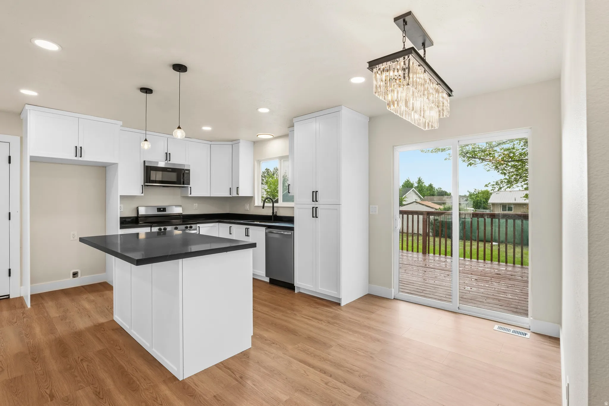 Modern kitchen featuring white cabinetry, dark countertops, and stainless steel appliances