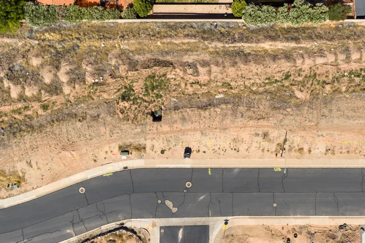 Undeveloped land parcel featuring a sloped terrain and partial vegetation