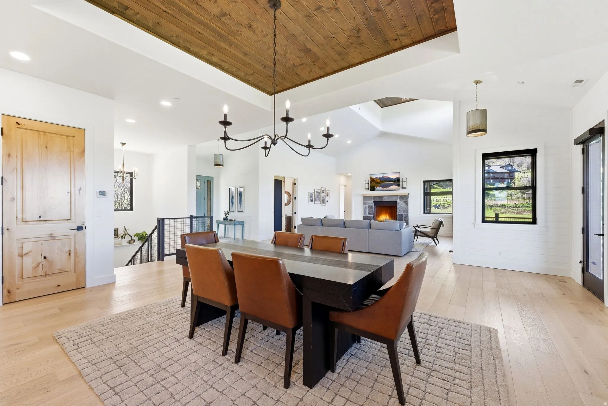 Dining area featuring a wood-panel ceiling accent and a black chandelier