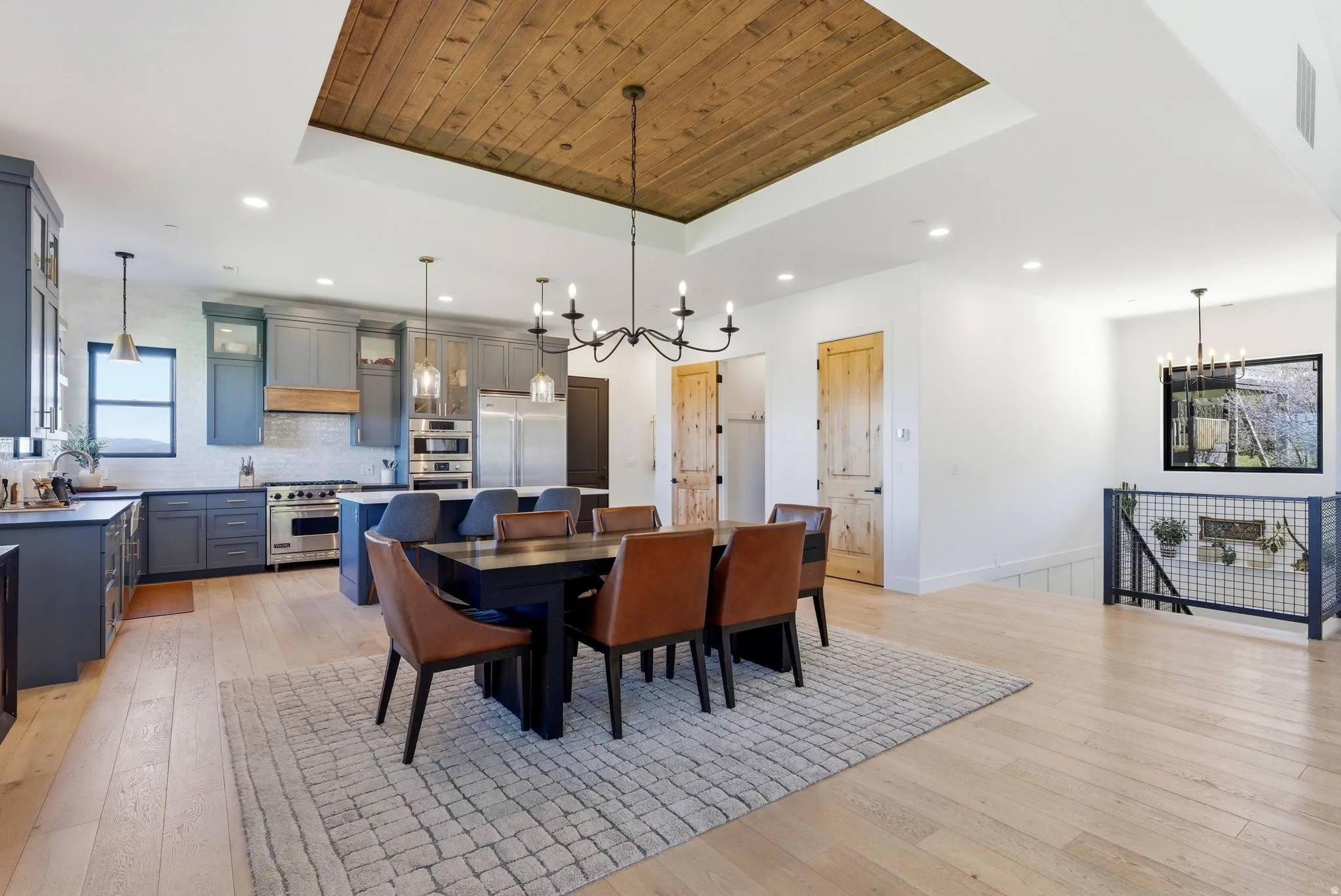 Open-concept living space featuring wood-finish flooring and a recessed ceiling with wood paneling