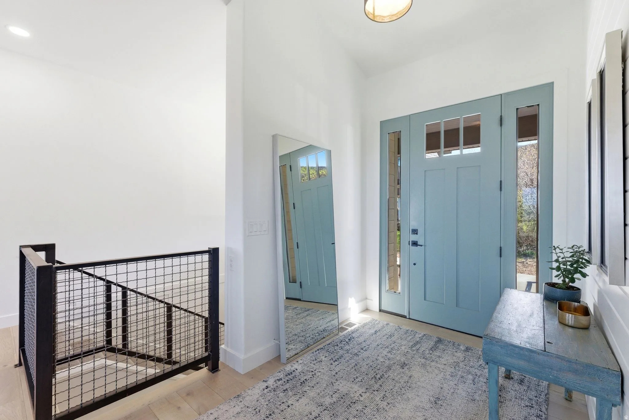 Light blue front door with transom windows and sidelights