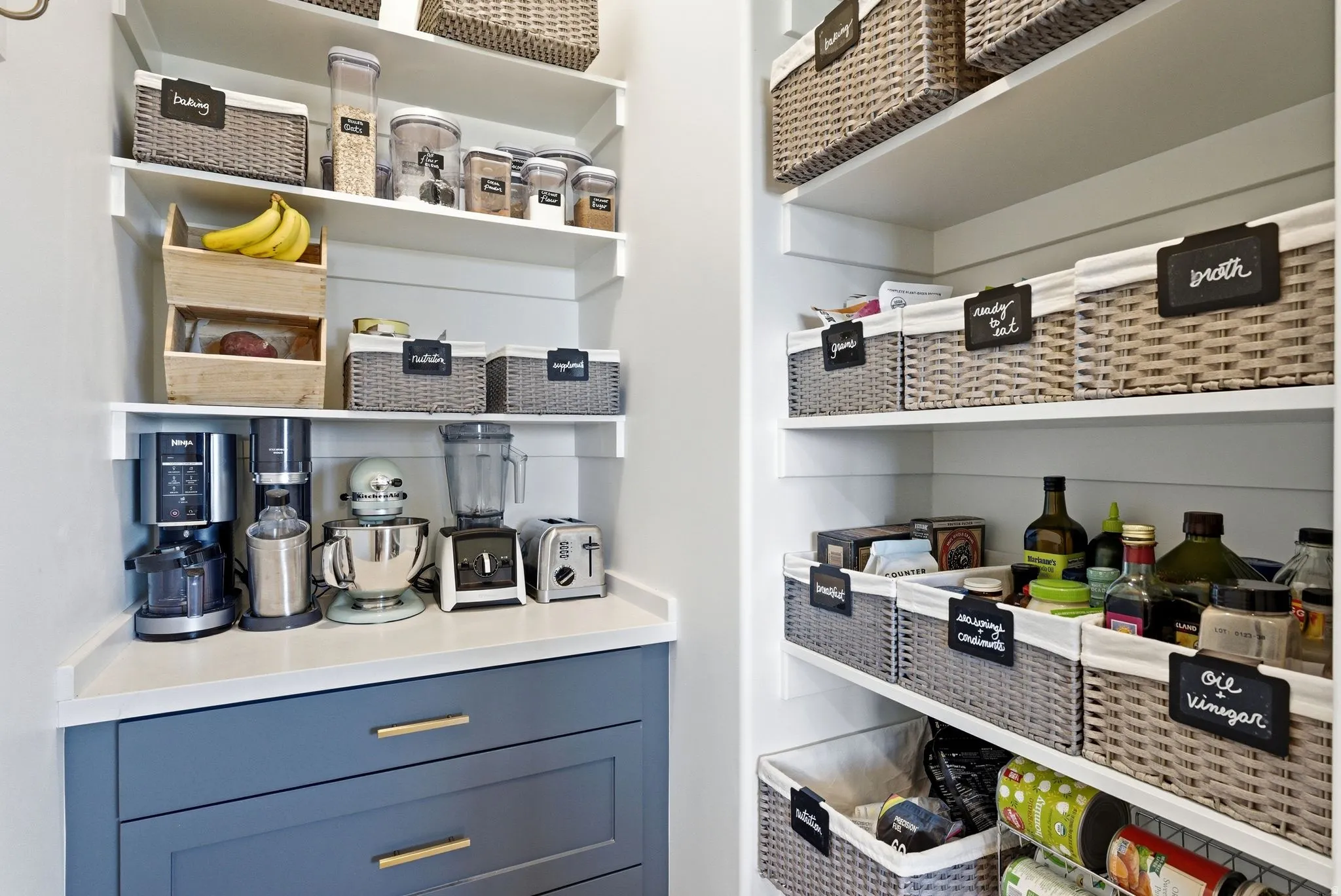 Custom pantry featuring extensive built-in shelving, a white countertop, and base cabinetry with gold-tone hardware