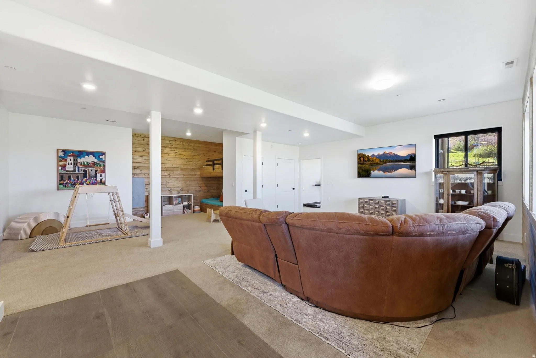 Spacious lower-level area featuring recessed lighting and a combination of wood-finish flooring and carpeting