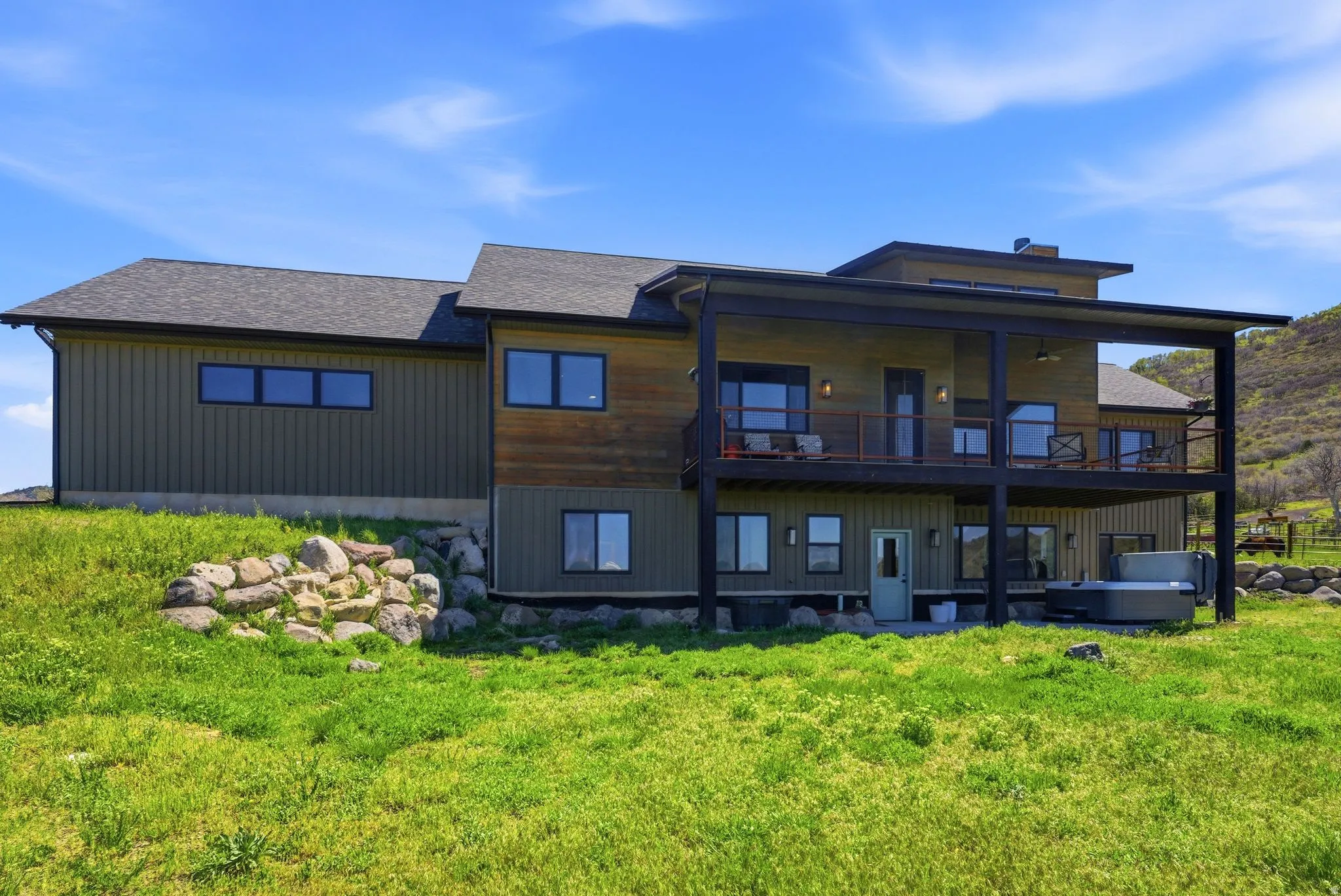 Contemporary two-story residence with a covered upper-level deck featuring dark railings