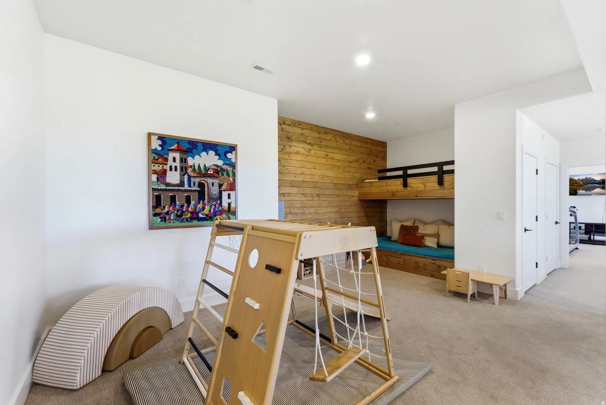 Recessed bunk beds with a shiplap accent wall, accompanied by light-colored carpeting