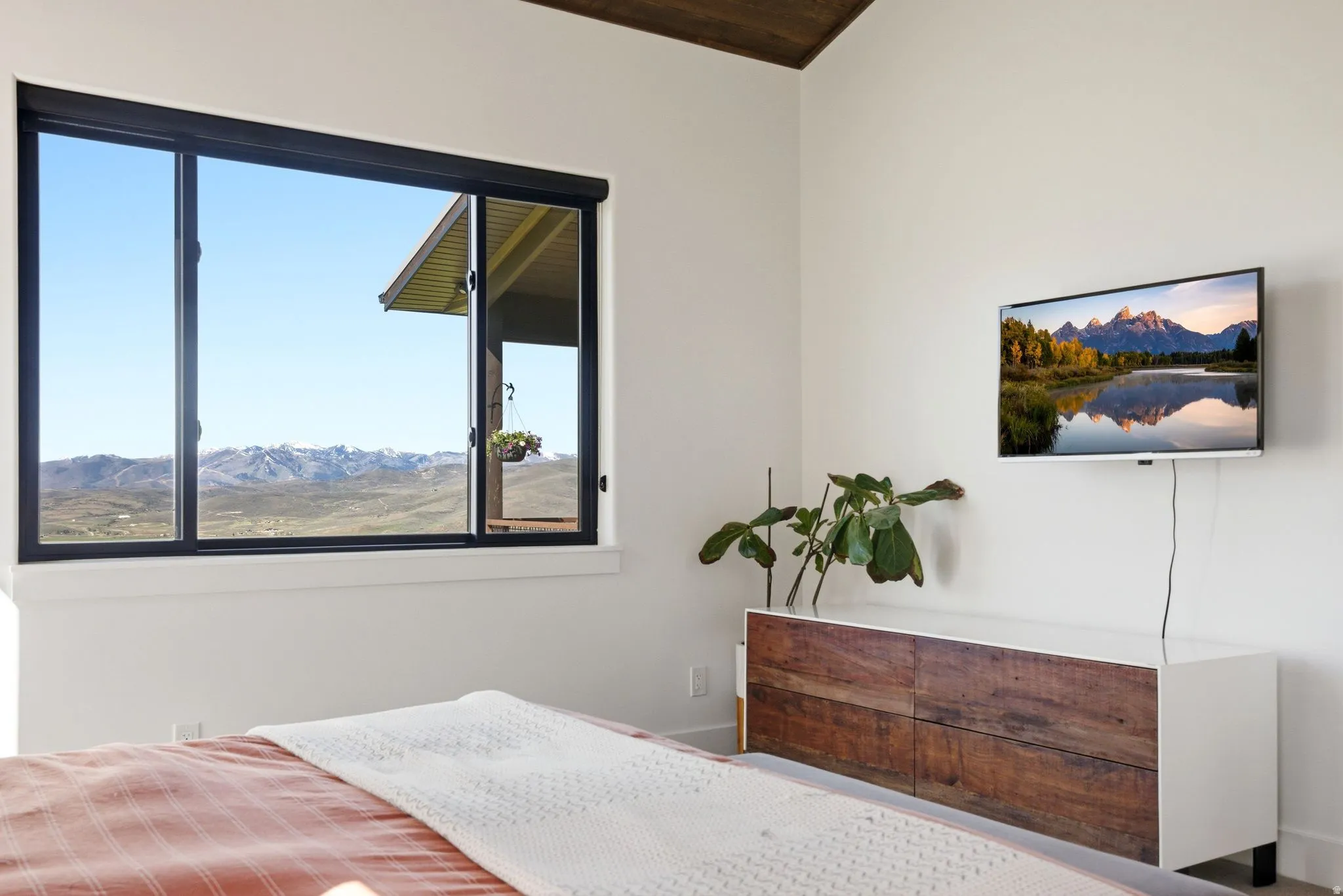 Expansive window with black framing revealing distant mountain scenery