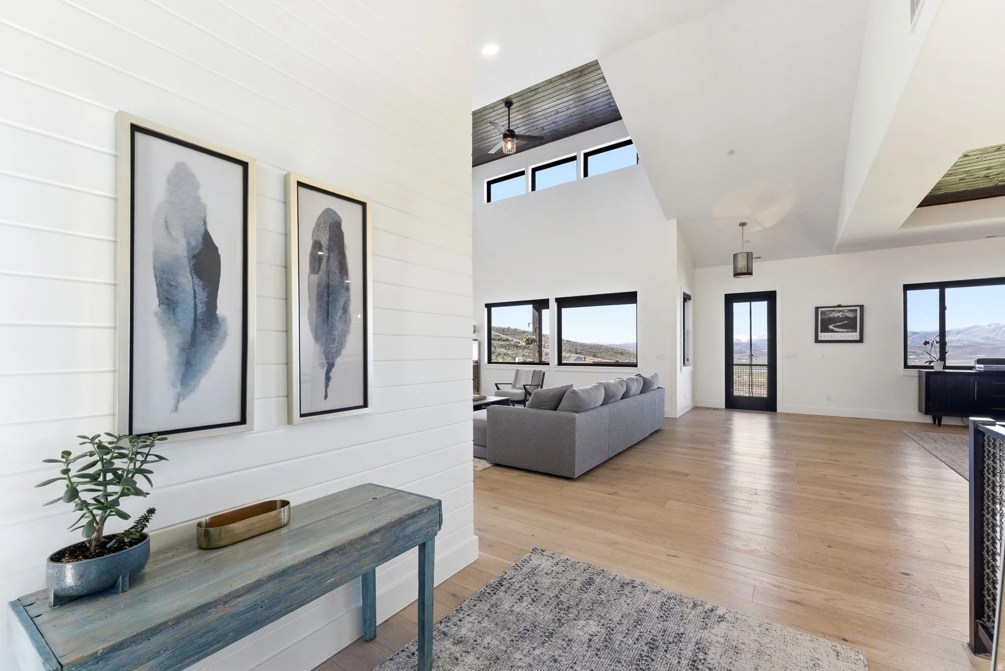 Spacious open-concept interior featuring light wood-finish flooring and white shiplap wall paneling